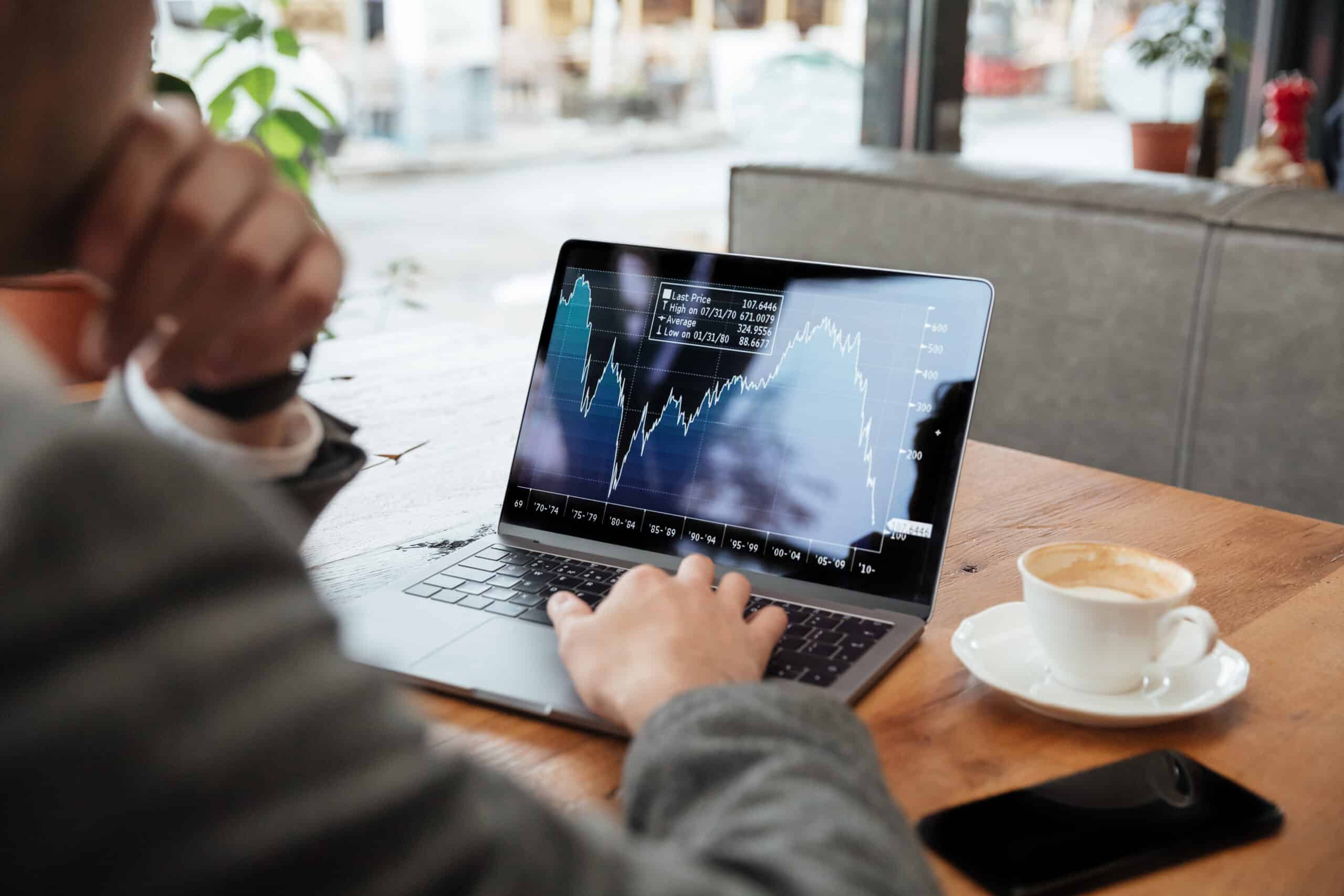 cropped image businessman sitting by table cafe analyzing indicators 1 scaled